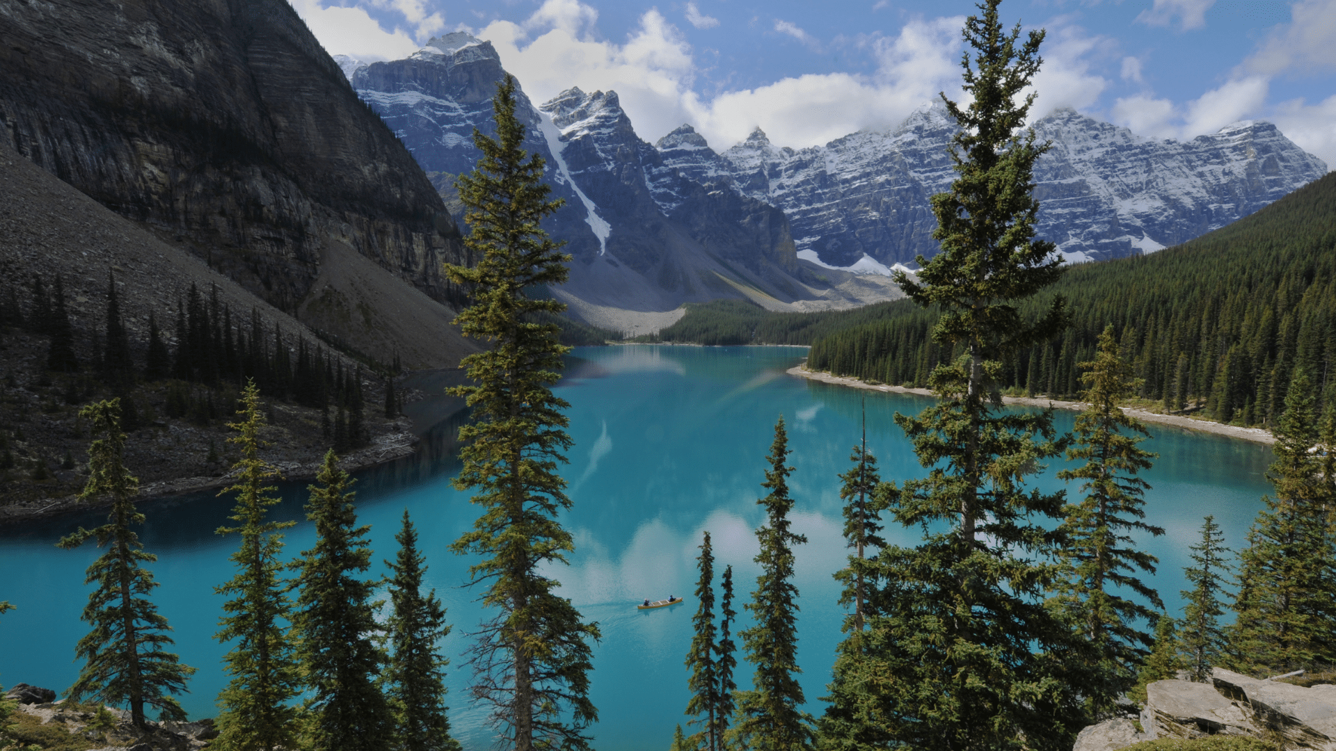Turquoise alpine lake in Banff National Park surrounded by mountains and pine trees, highlighting Calgary’s proximity to the Rockies
