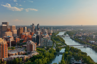 Relocating to Calgary guide featuring the downtown Calgary skyline and Bow River, highlighting lifestyle, neighbourhoods, and quality of life.